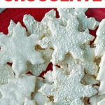 vanilla cookies in snowflake and tree shapes stacked on a red plate.