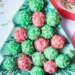red and green coconut balls arranged on a tree shaped plate on a table.