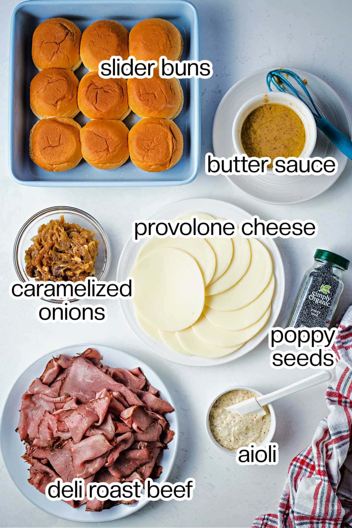 Ingredients for roast beef sliders on a table.