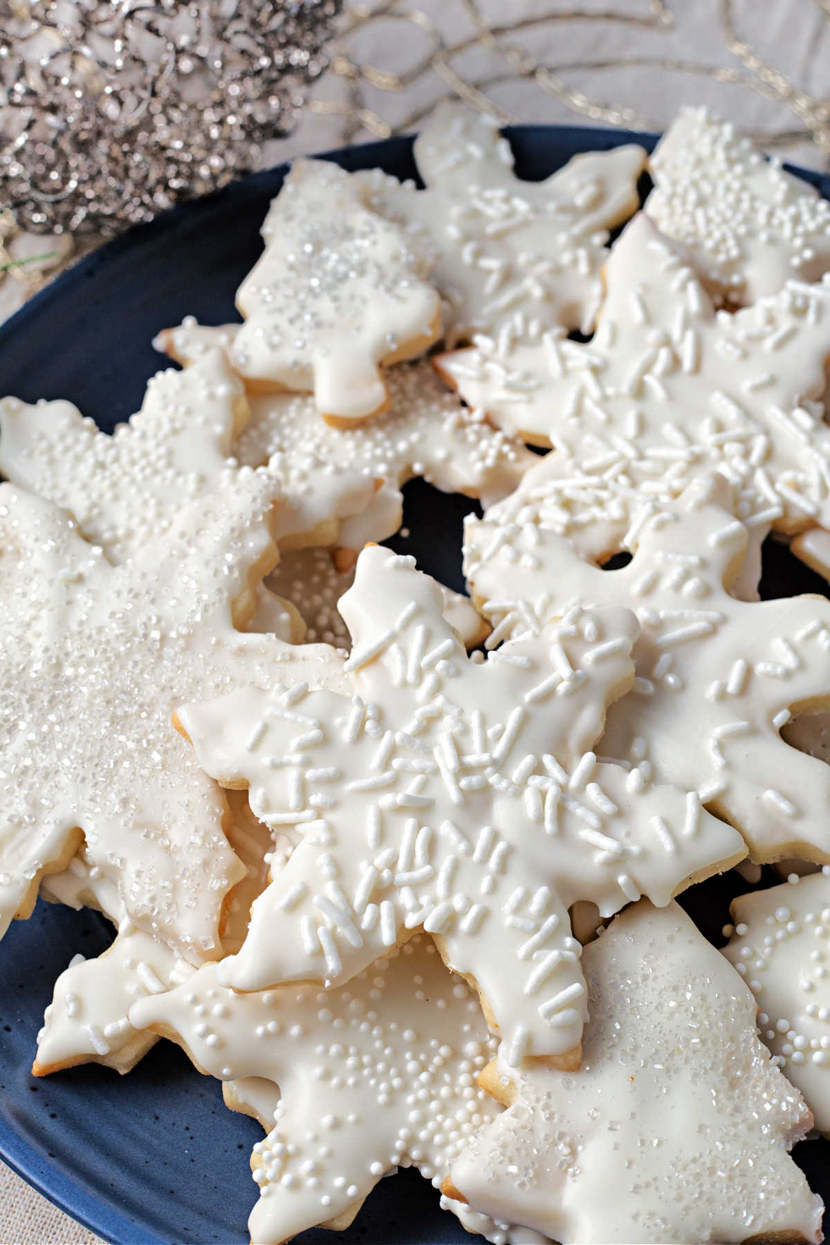 vanilla cookies in star shapes stacked on a plate onto a table.