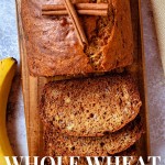 a loaf of whole wheat banana bread on a wooden board with a few slices cut and laying in front.