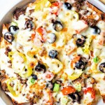 a pan of Italian nachos with melted mozzarella on top.