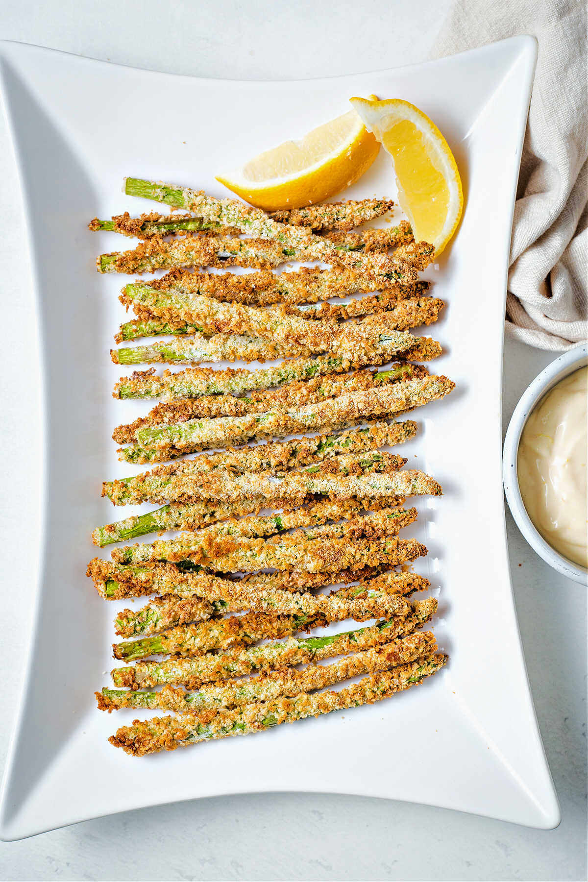 air fryer asparagus veggie fries on a plate with a bowl of lemon garlic aioli for dipping.