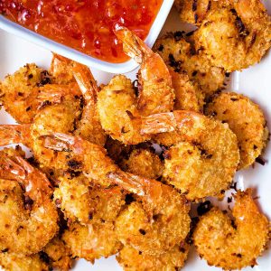 air fryer coconut shrimp piled on a plate.