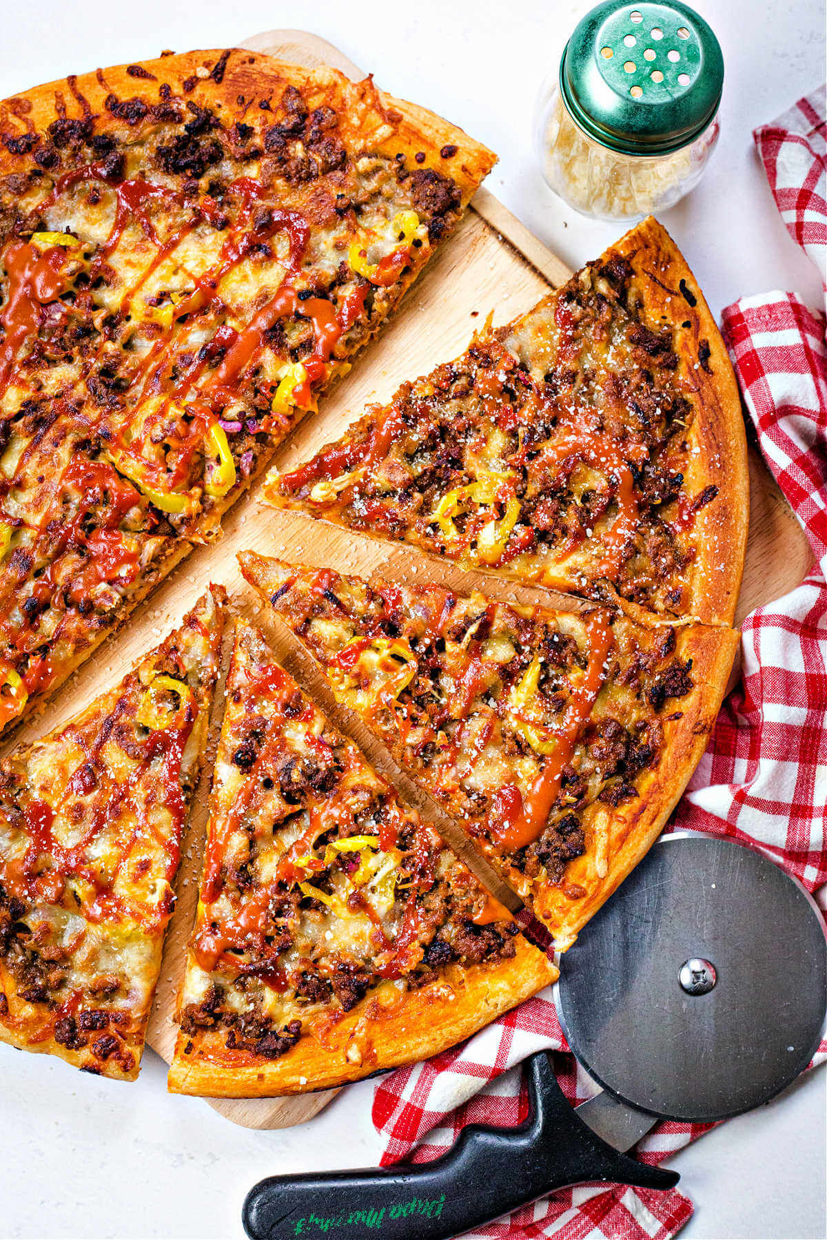 cheeseburger pizza on a pizza wheel.