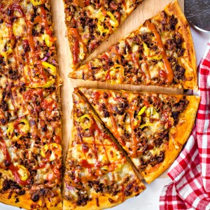 slices of cheeseburger pizza on a pizza wheel.