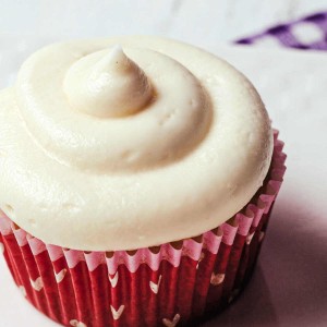 a vanilla cupcake with sour cream frosting swirled on top.