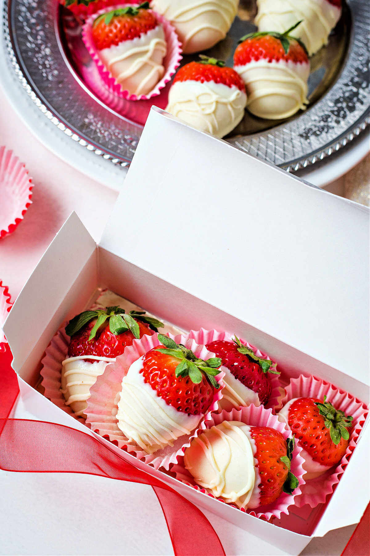 a gift box filled with white chocolate dipped strawberries.