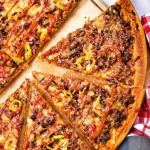 slices of cheeseburger pizza on a pizza wheel.