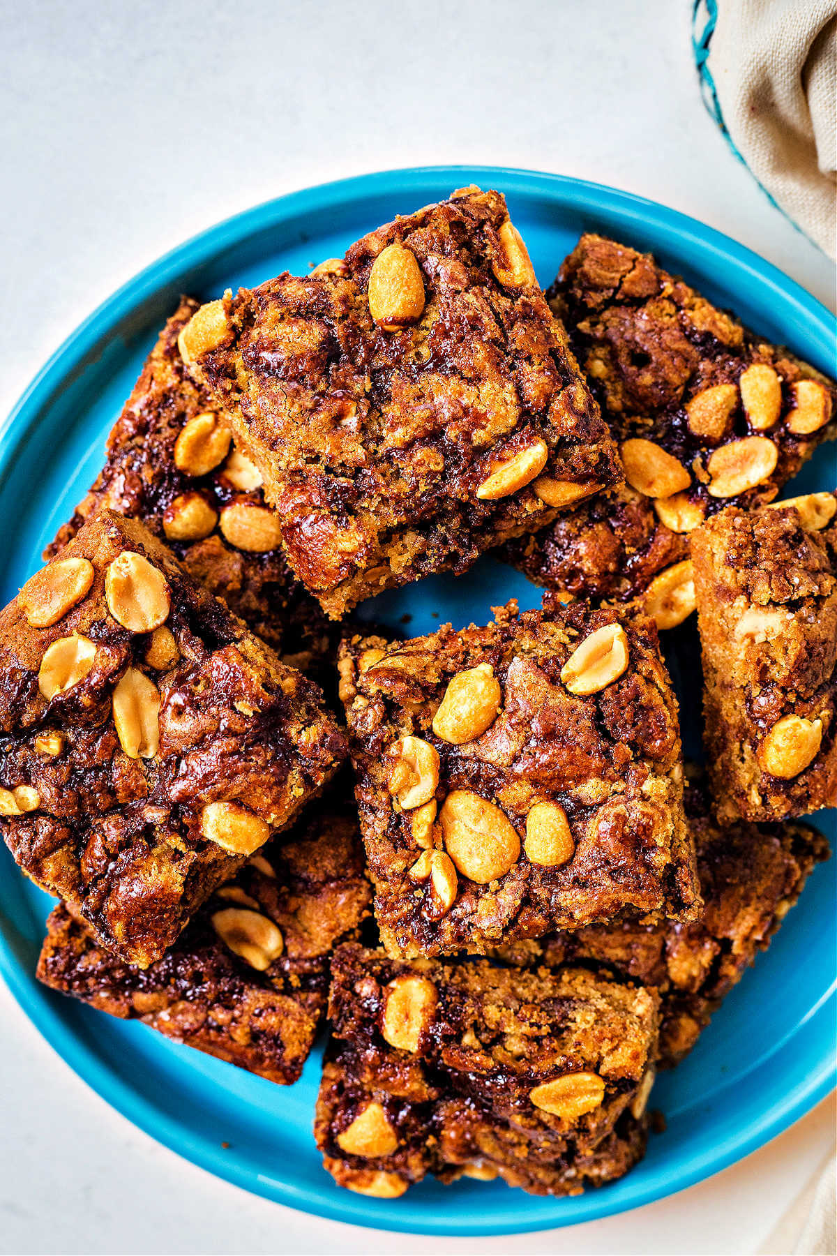 top down view of peanut butter brownies stacked on top of each other on a blue plate.