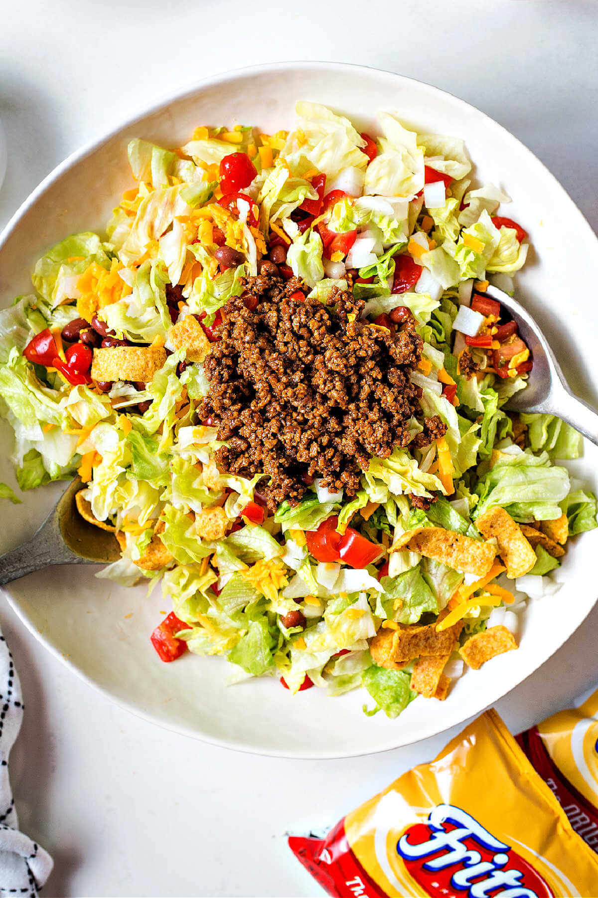 adding cooked taco meat to a bowl of catalina taco salad.