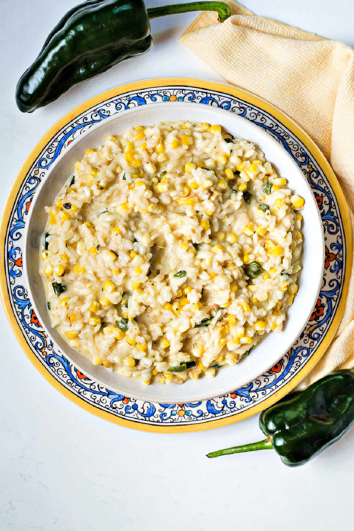 arroz poblano in a bowl sitting on a decorative plate on a table.