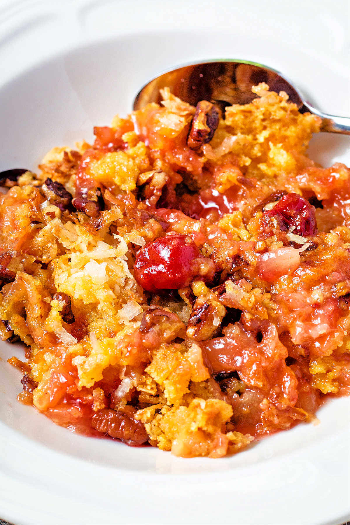 cherry dump cake in a white bowl.