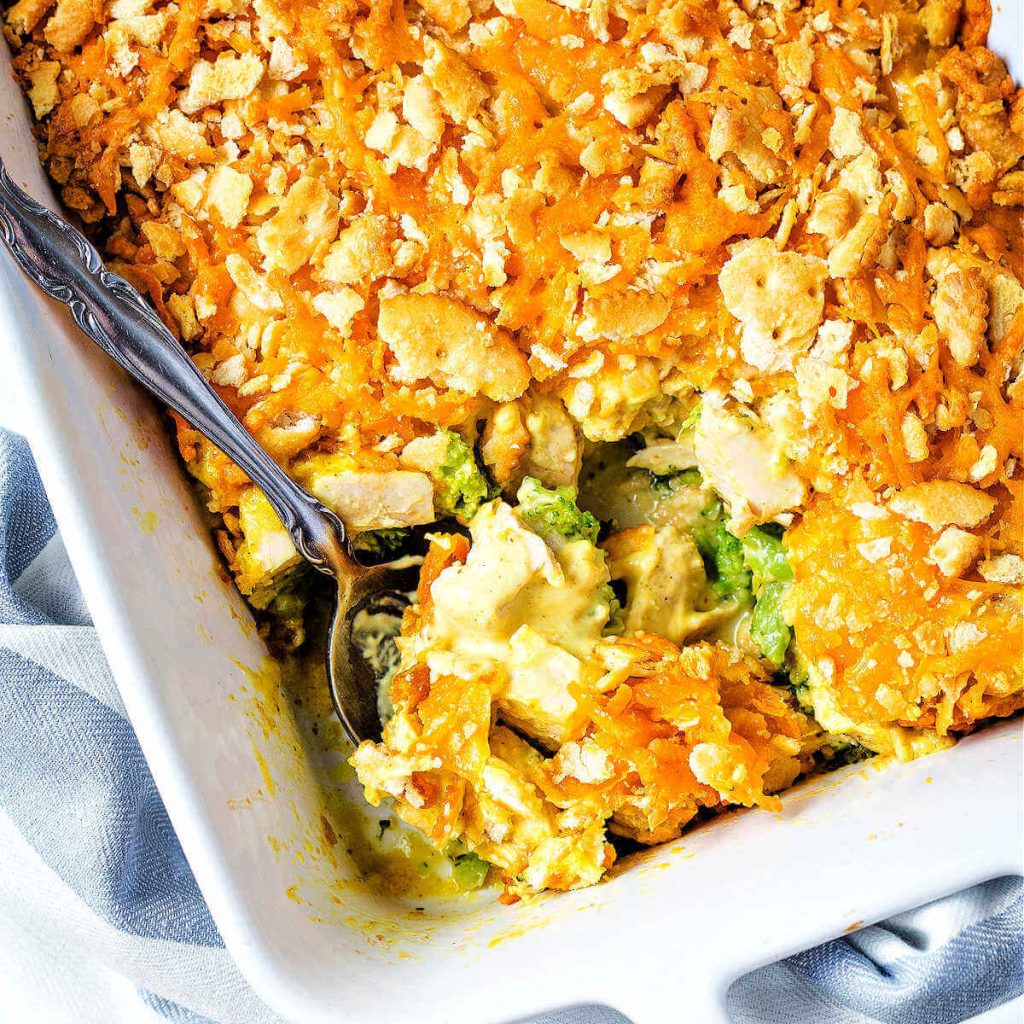 a serving spoon inserted into a baked chicken broccoli casserole.
