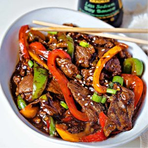 pepper steak in a bowl with chopsticks.