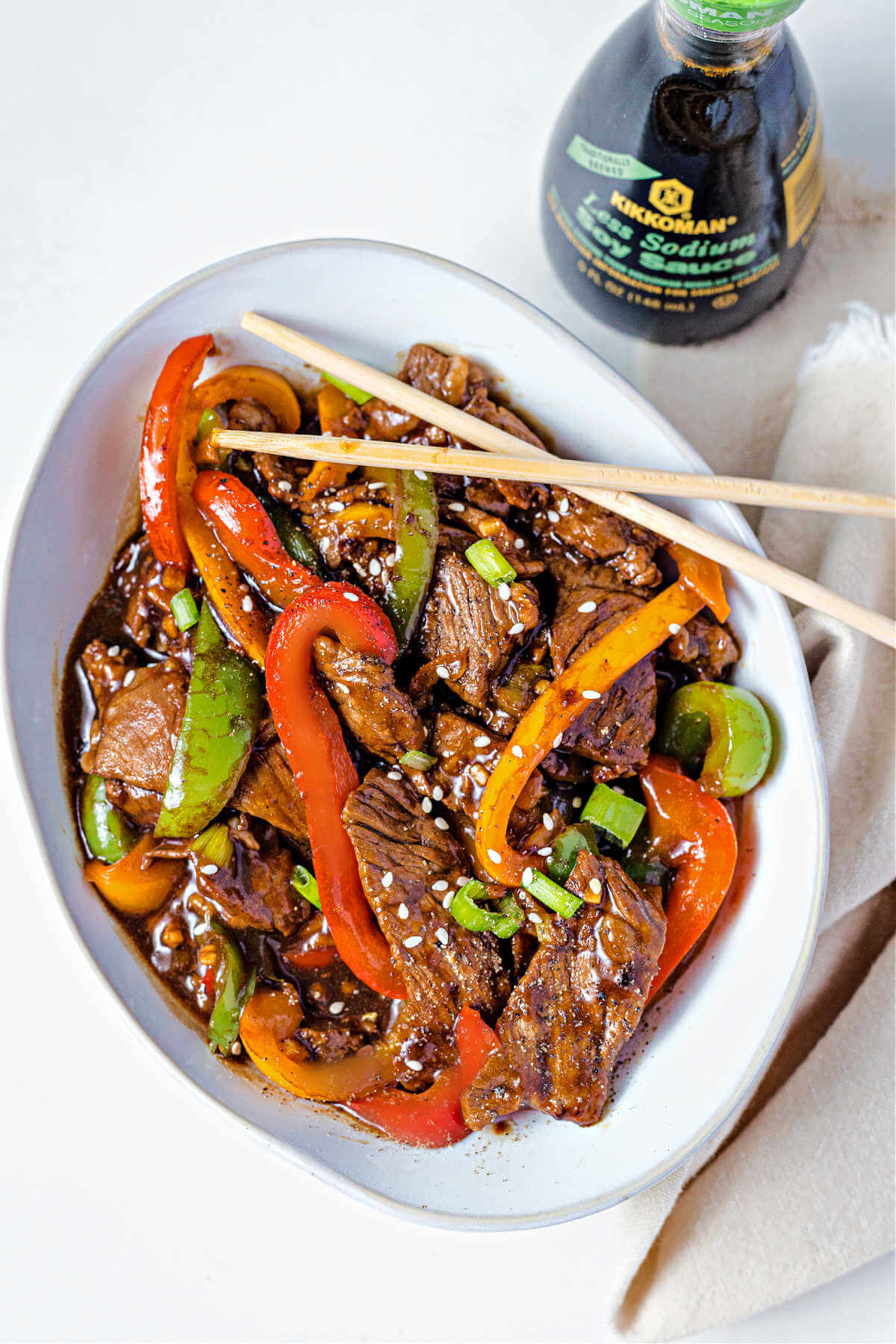 pepper steak in a bowl with chopsticks.