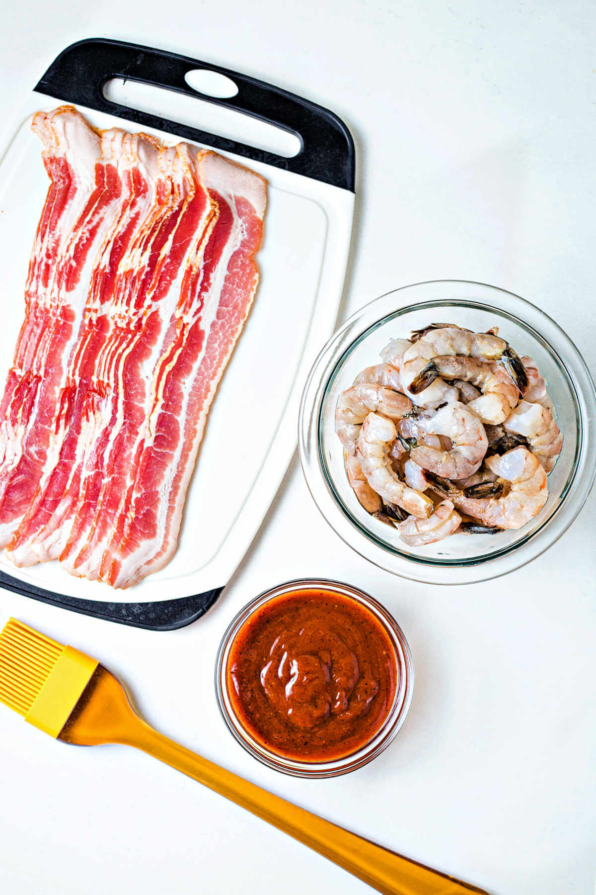 ingredients for bacon wrapped shrimp on a table.