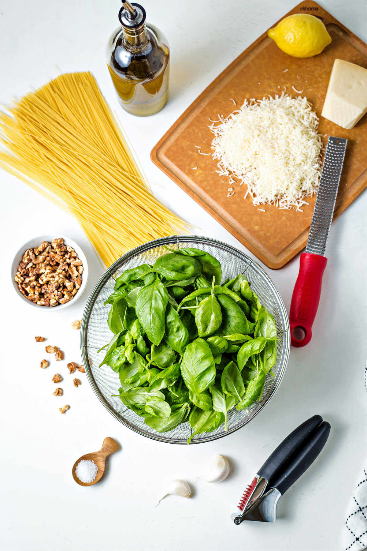 ingredients for making basil pesto pasta on a table.
