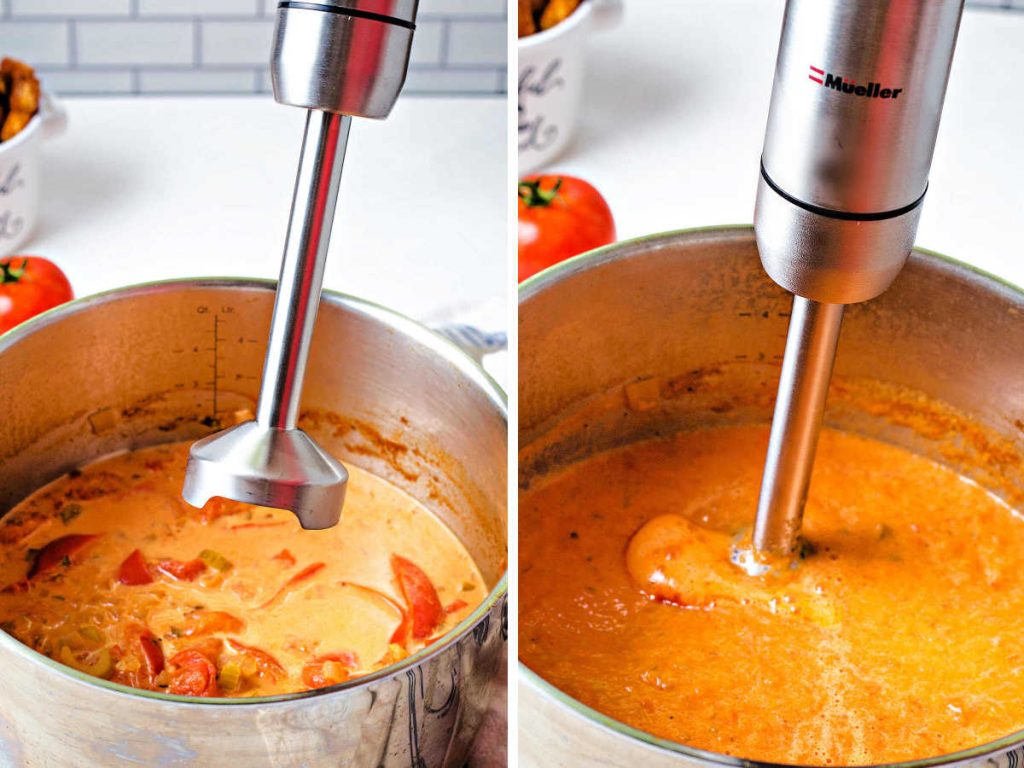 using an immersion blender to blend up tomato soup in a pot.
