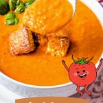 a spoonful of Creamy Tomato Soup with parmesan cornbread croutons in a bowl.