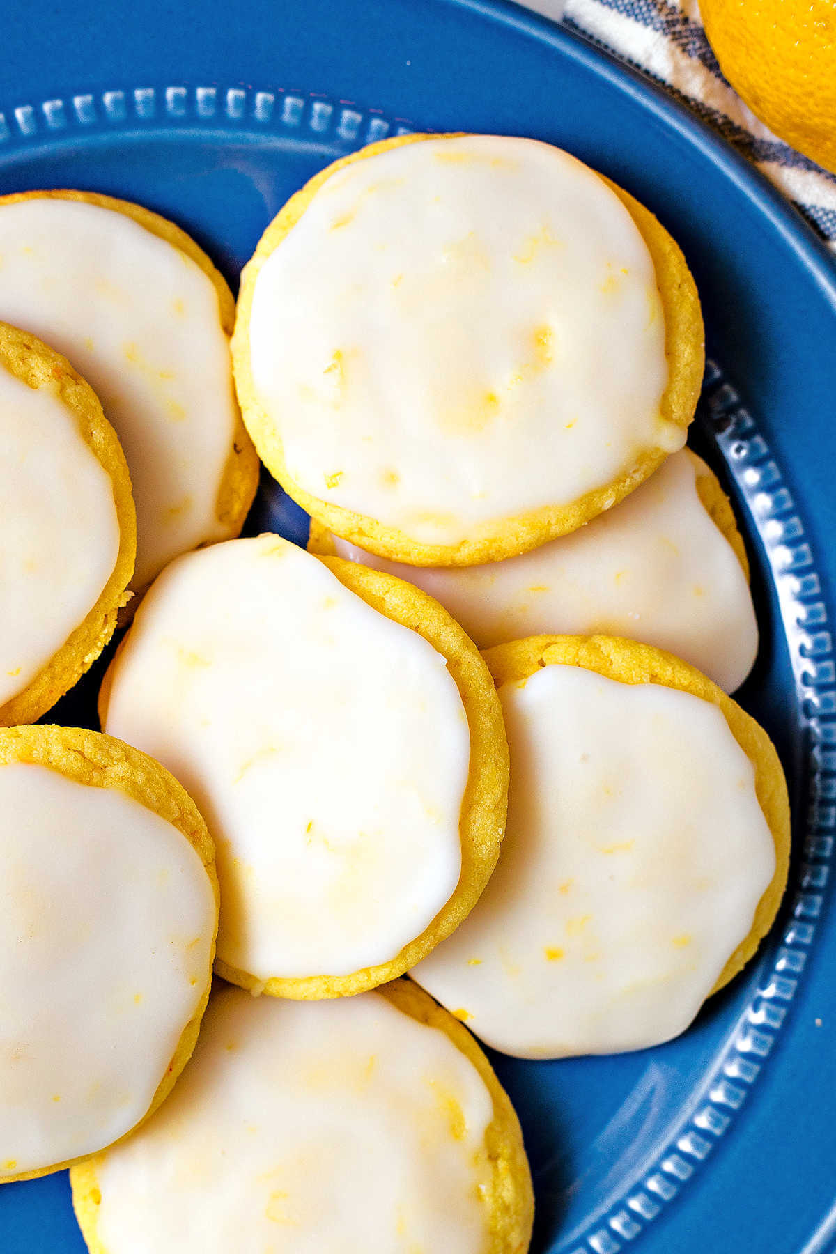 Lemon Cake Mix Cookies with lemon glaze on a blue plate.