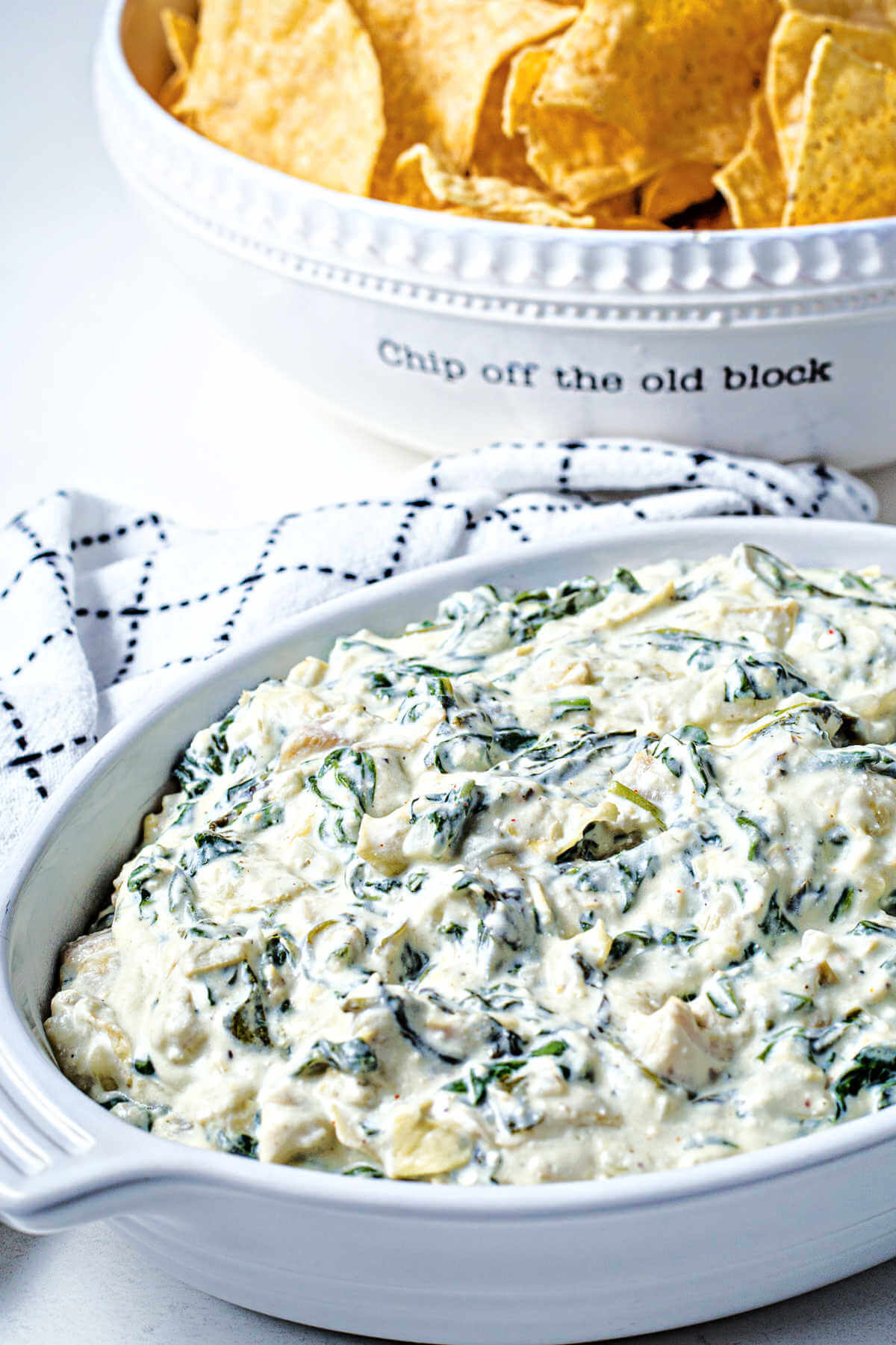 slow cooker spinach artichoke dip in a serving dish on a table.