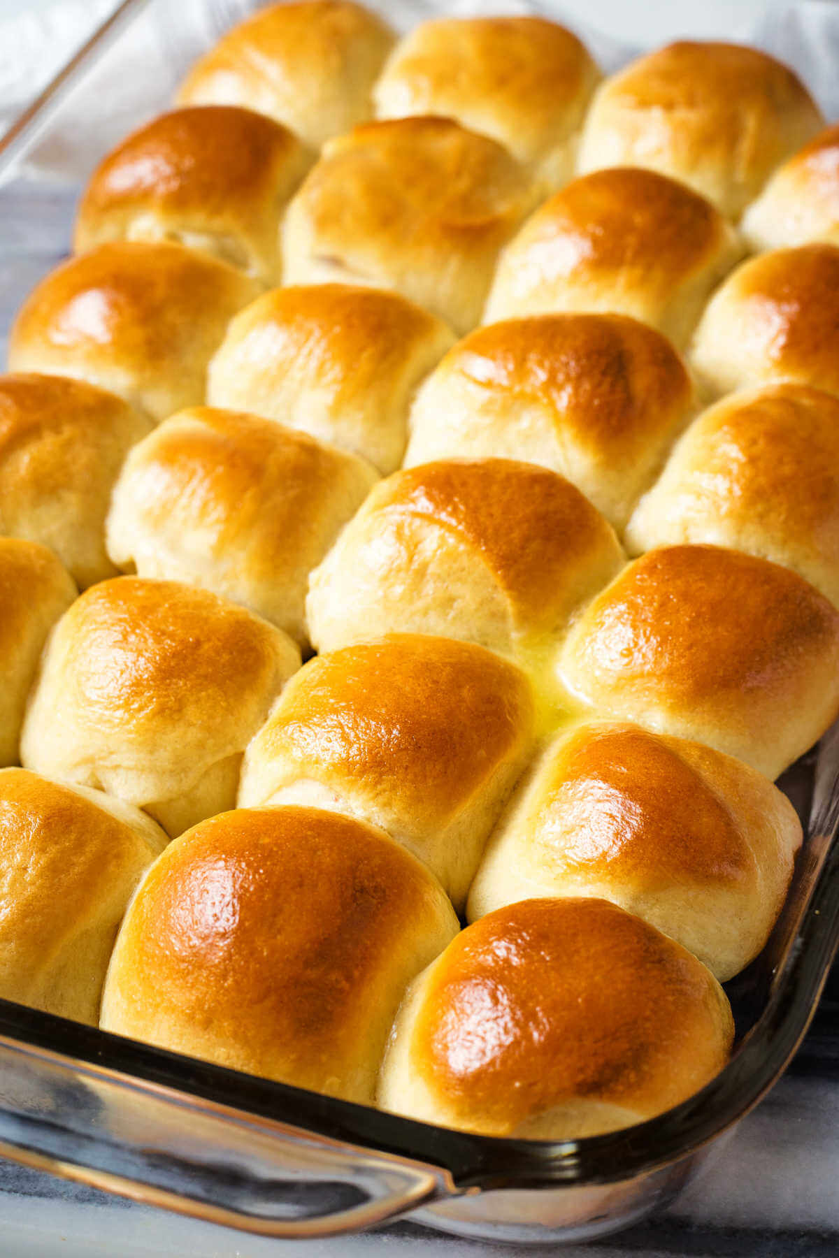 a pan of baked dinner rolls basted with butter.