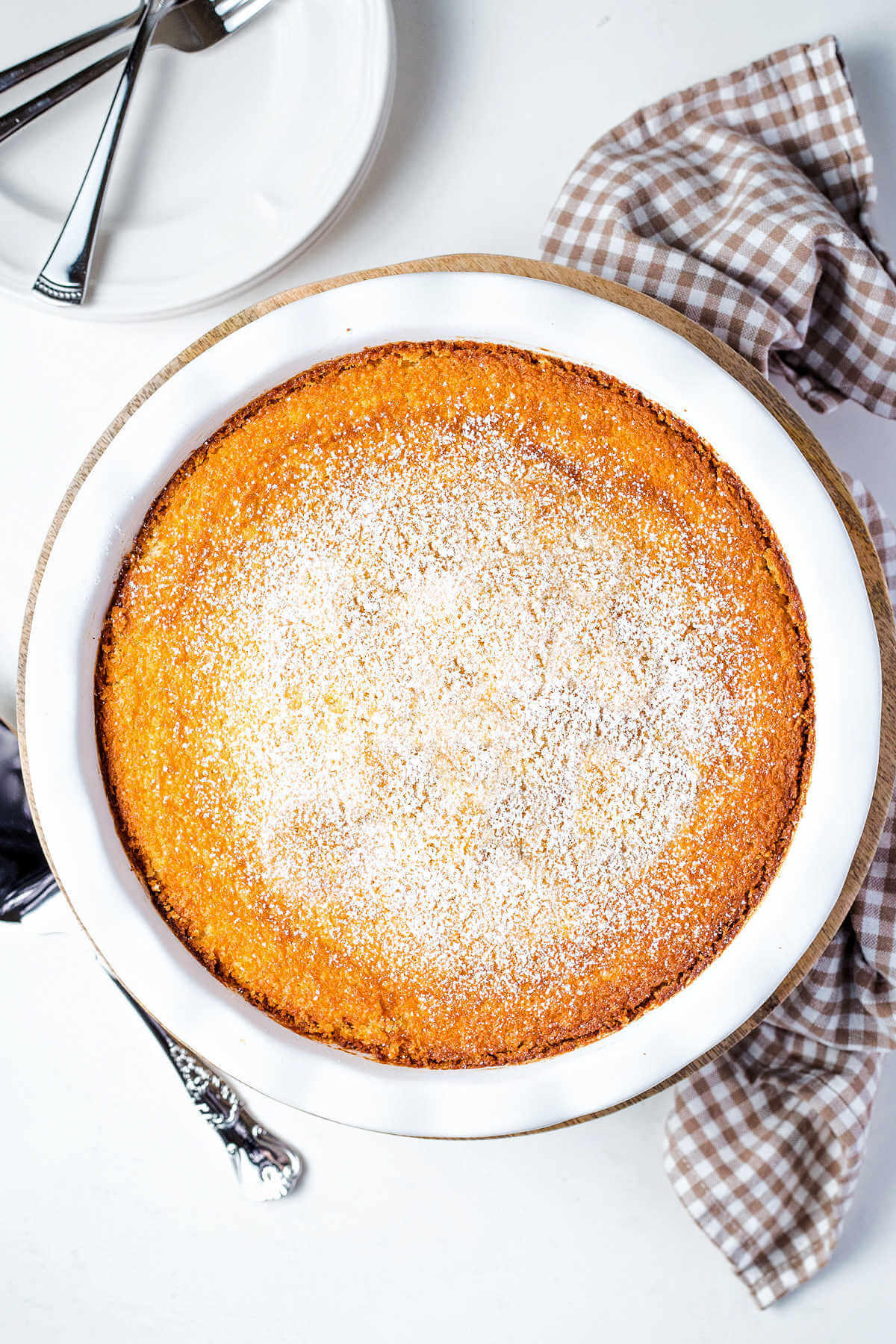 a whole impossible pie dusted with powdered sugar on a table.