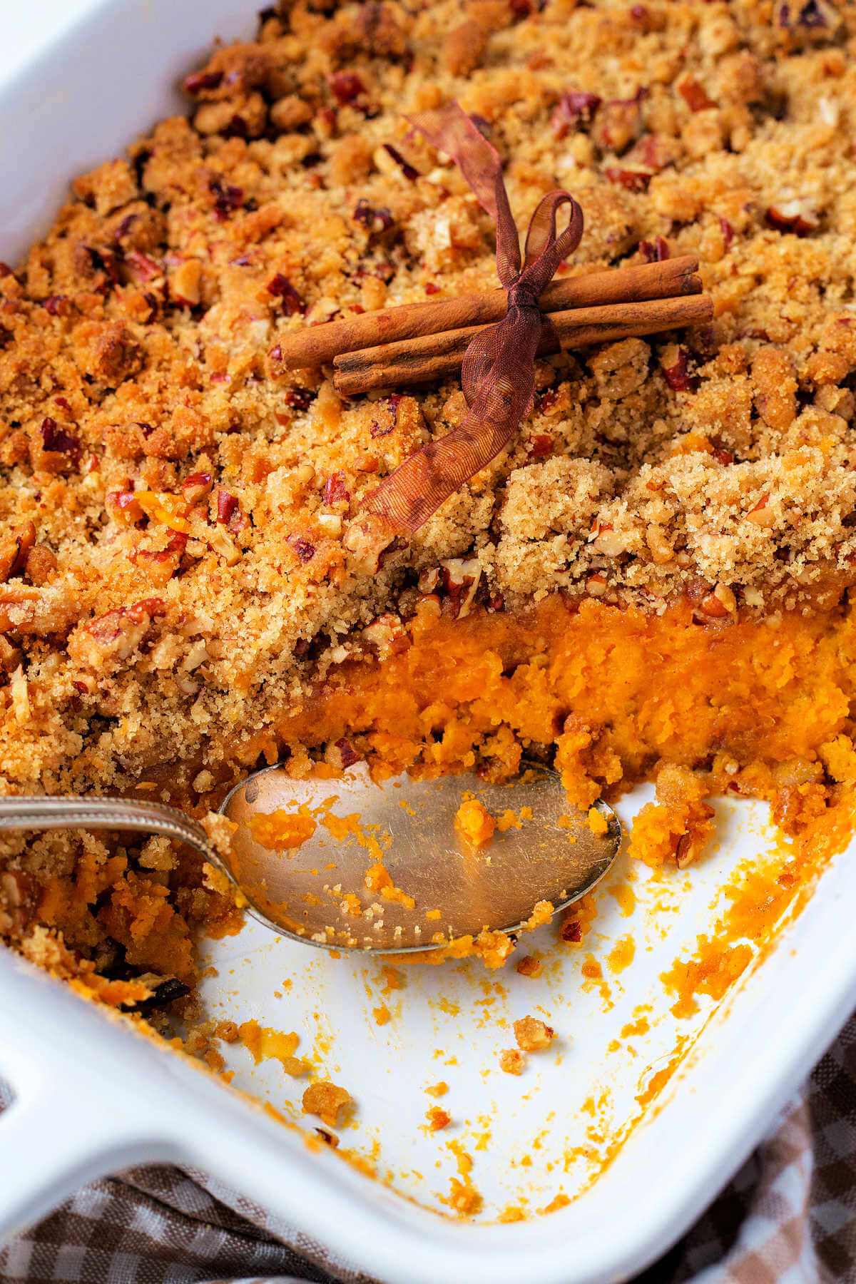 sweet potato souffle in a white baking dish with a serving scooped out.