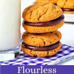 two Flourless Peanut Butter & Chocolate Sandwich Cookies leaning against a glass of milk.