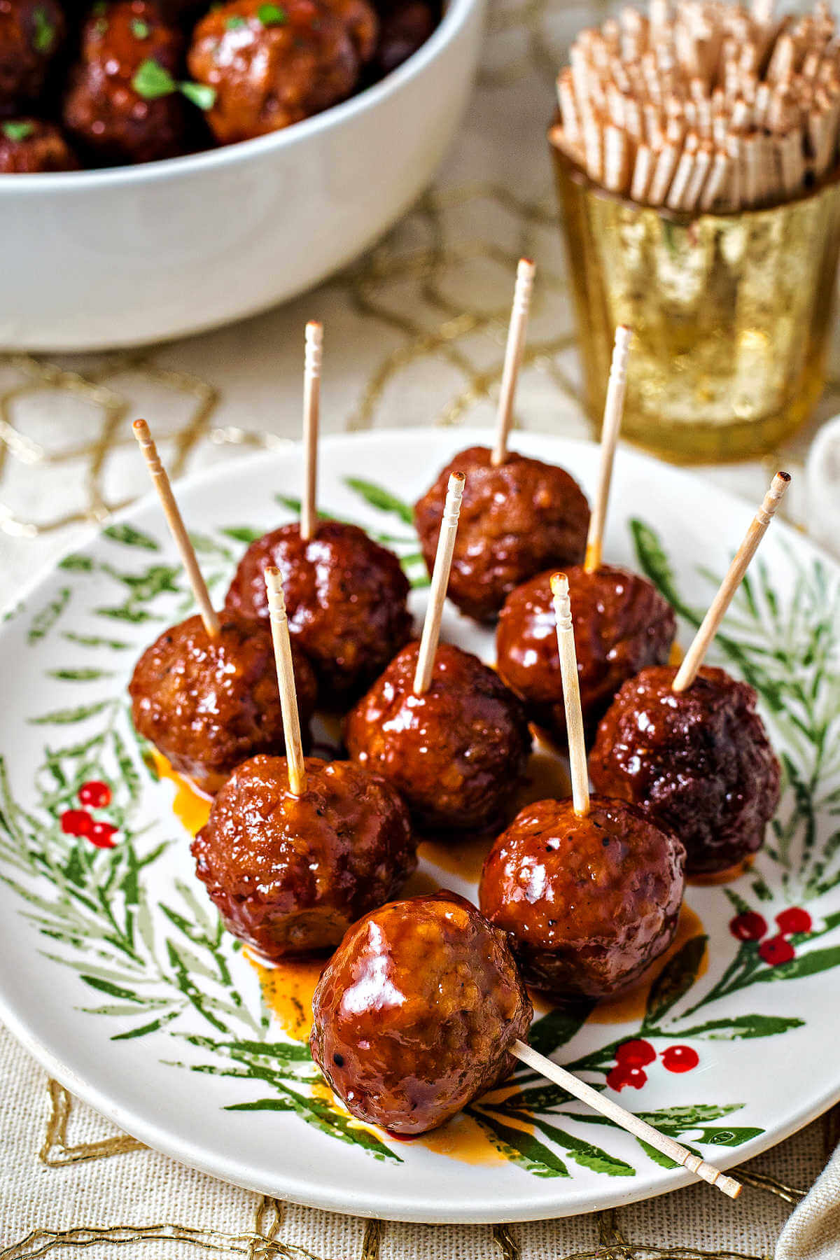 grape jelly meatballs on a Christmas plate with toothpicks.