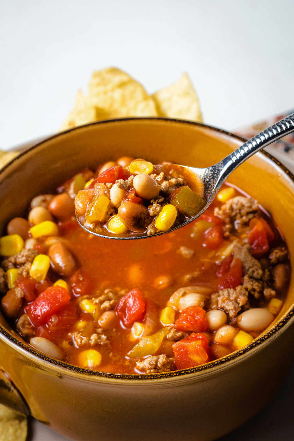 a spoonful of taco soup rising out of a bowl.