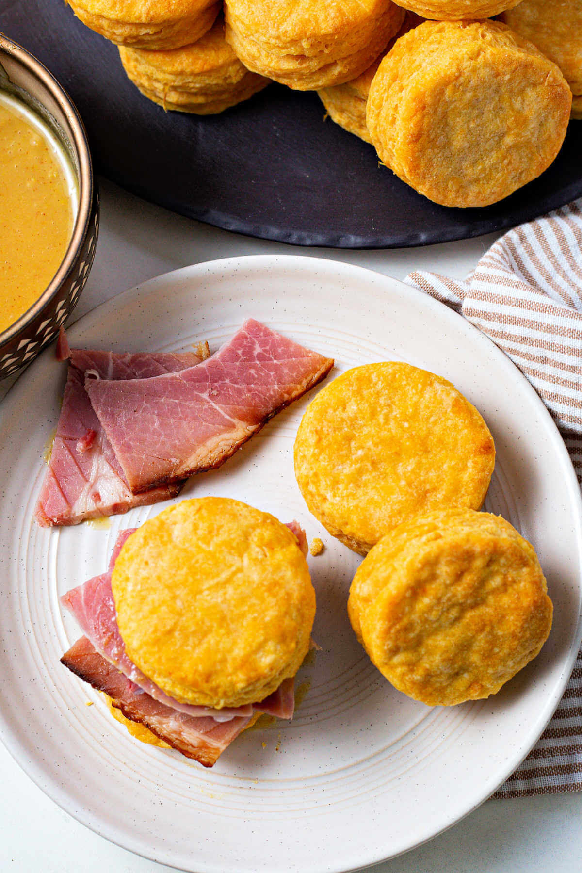 sweet potato biscuits on a plate with slices of ham.