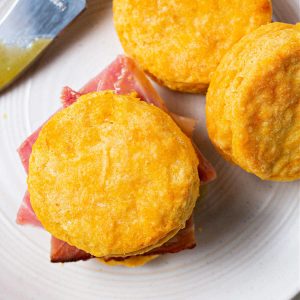 a sweet potato biscuit stuffed with ham on a plate.