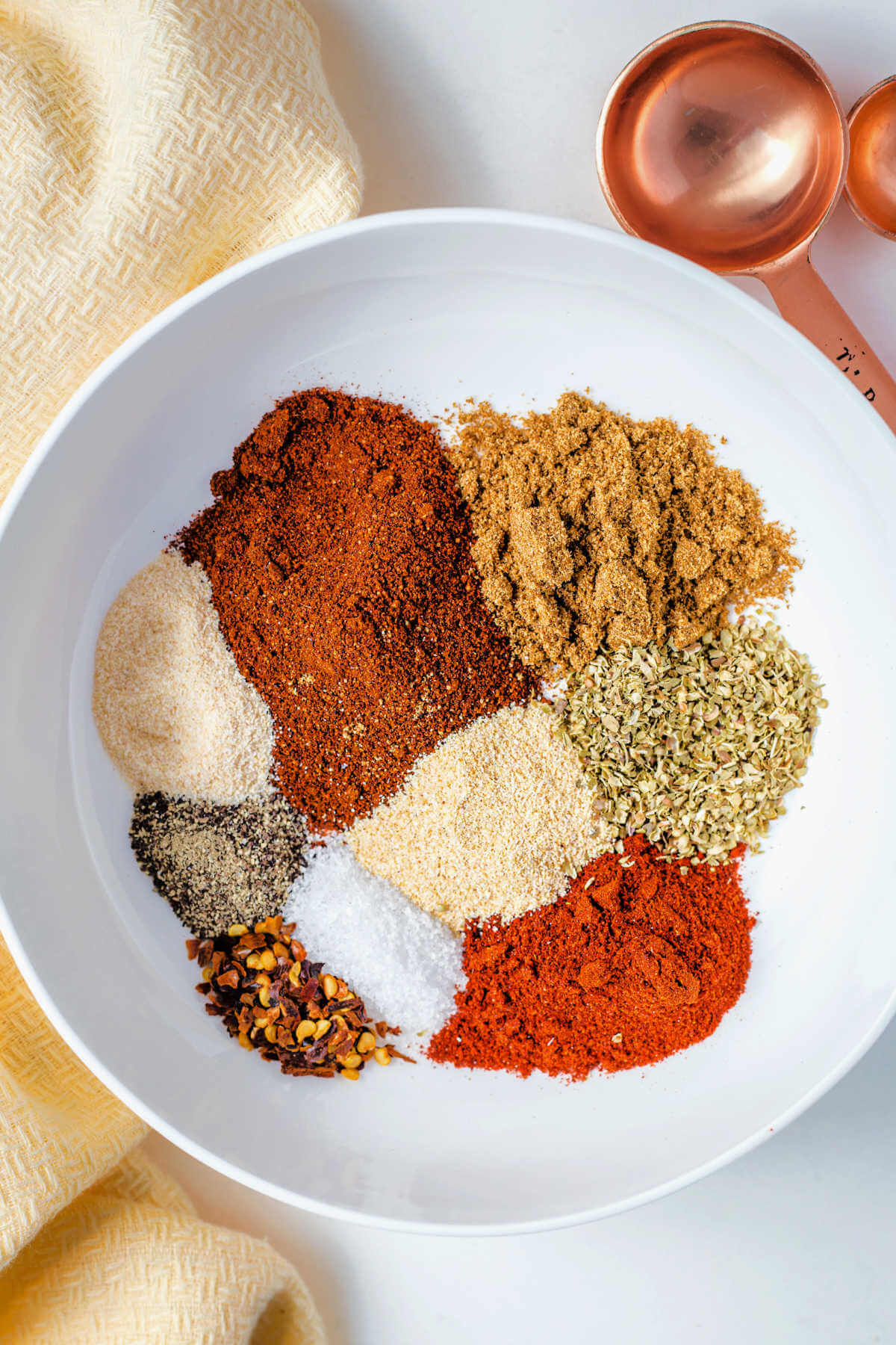 spices for taco seasoning in a bowl on a table.