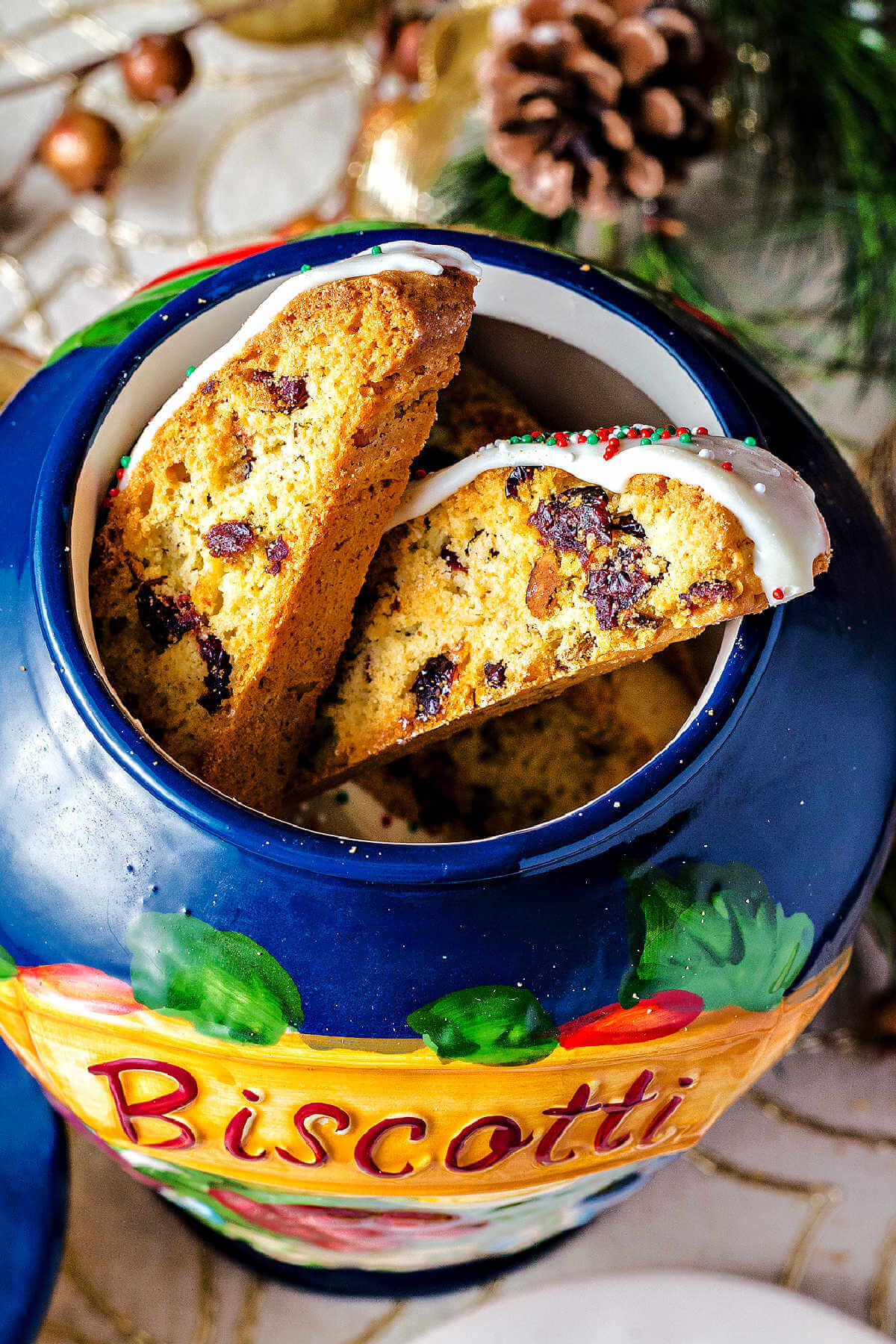 cranberry pistachio biscotti stacked in a cookie jar.