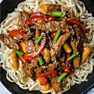 Korean Beef Stir Fry served over lo mein noodles and garnished with diced green onions and sesame seeds.