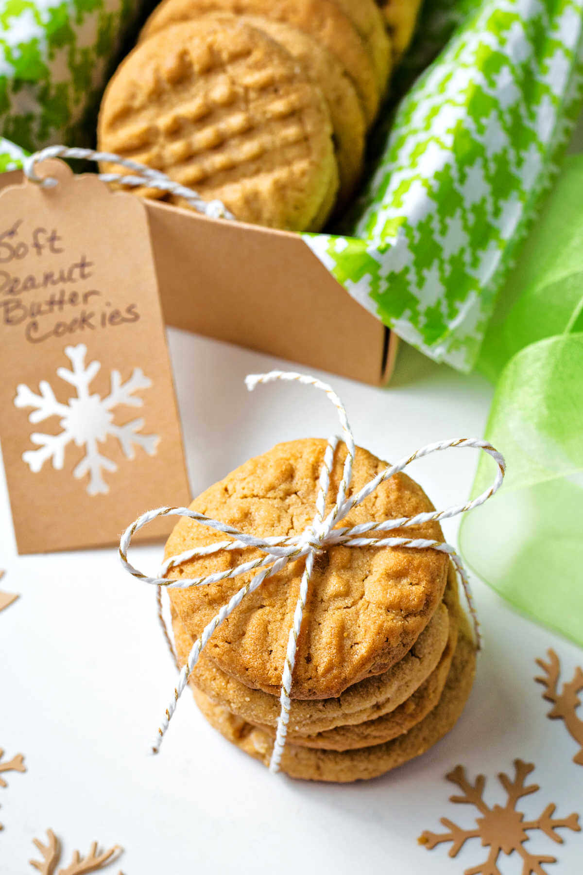 soft peanut cookies tied up with a string sitting on a table with another box of cookies in the background..