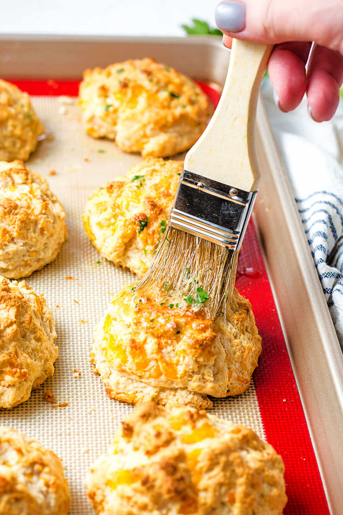basting cheddar bay biscuits with garlic butter with a pastry brush.