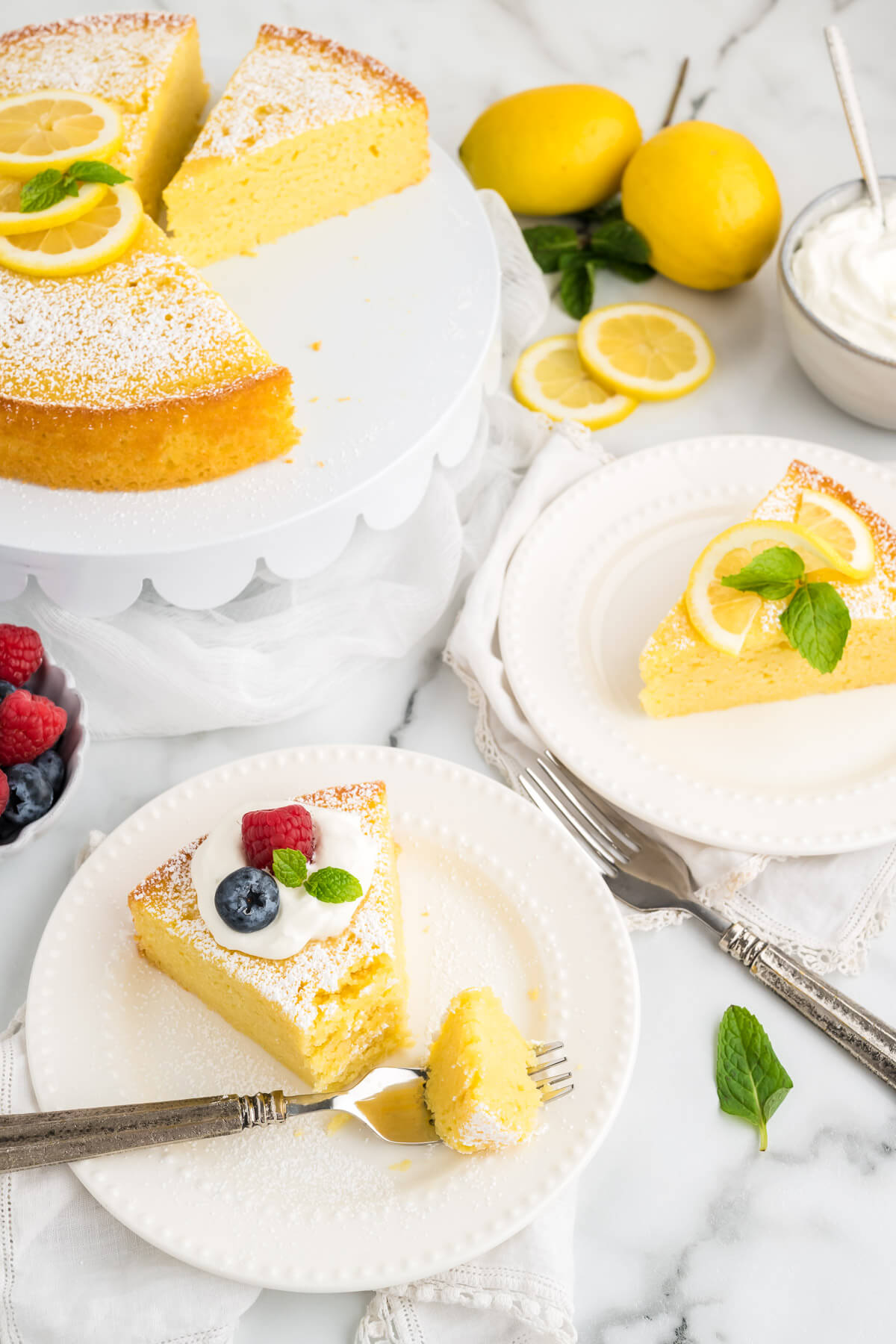 slices of lemon ricotta cake on serving plates with different garnishes.