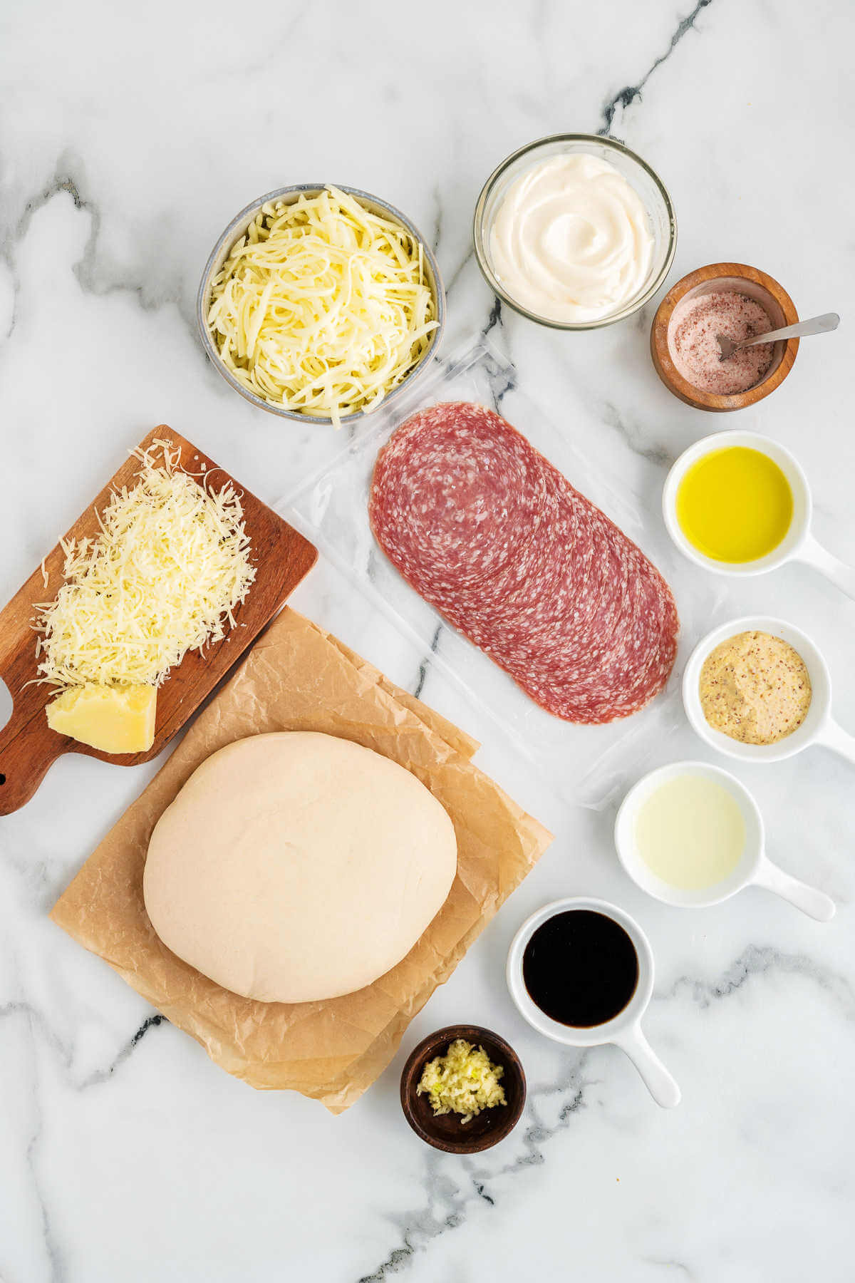 ingredients for salami pizza on a table.