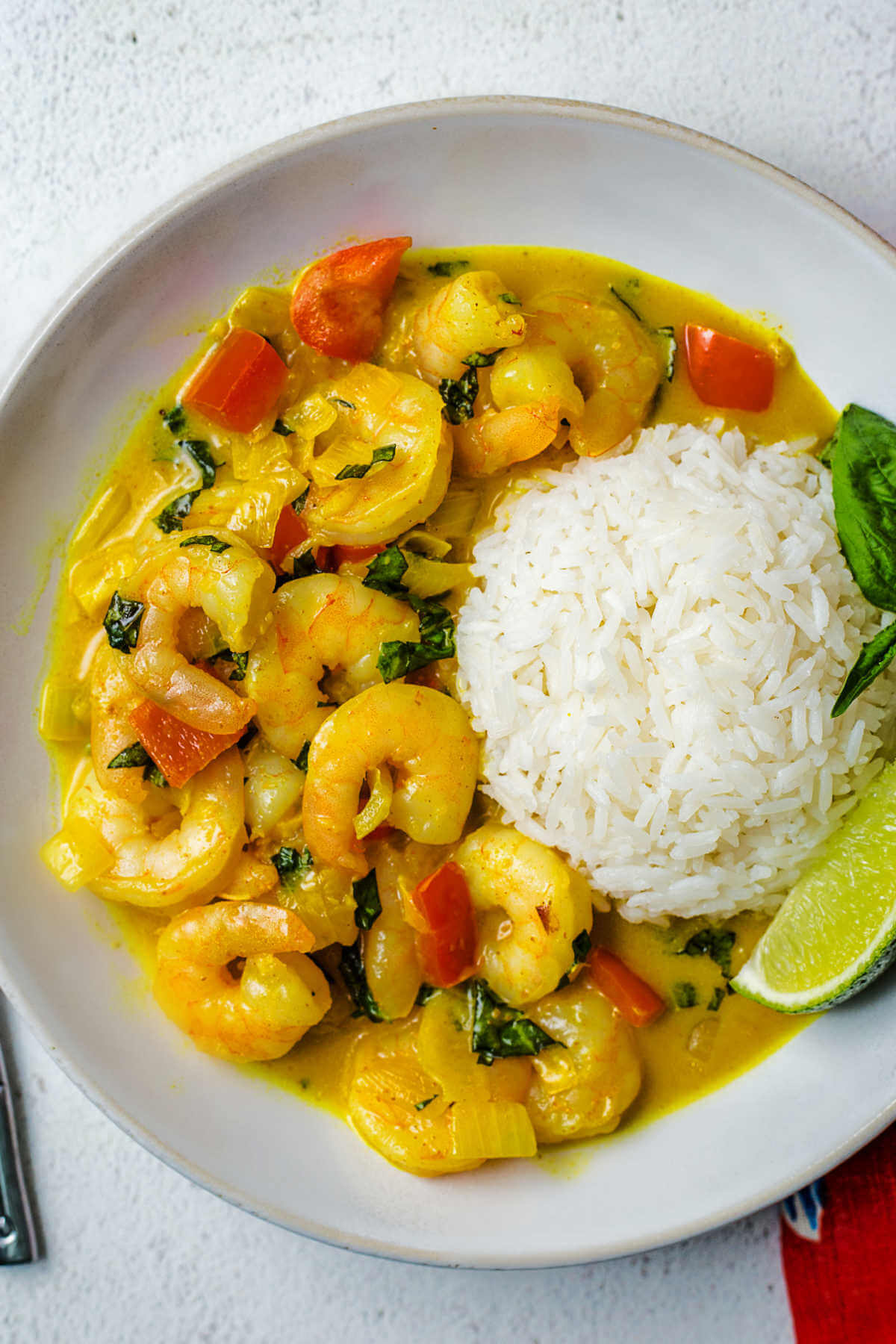 a serving of shrimp curry with rice in a bowl on a table.
