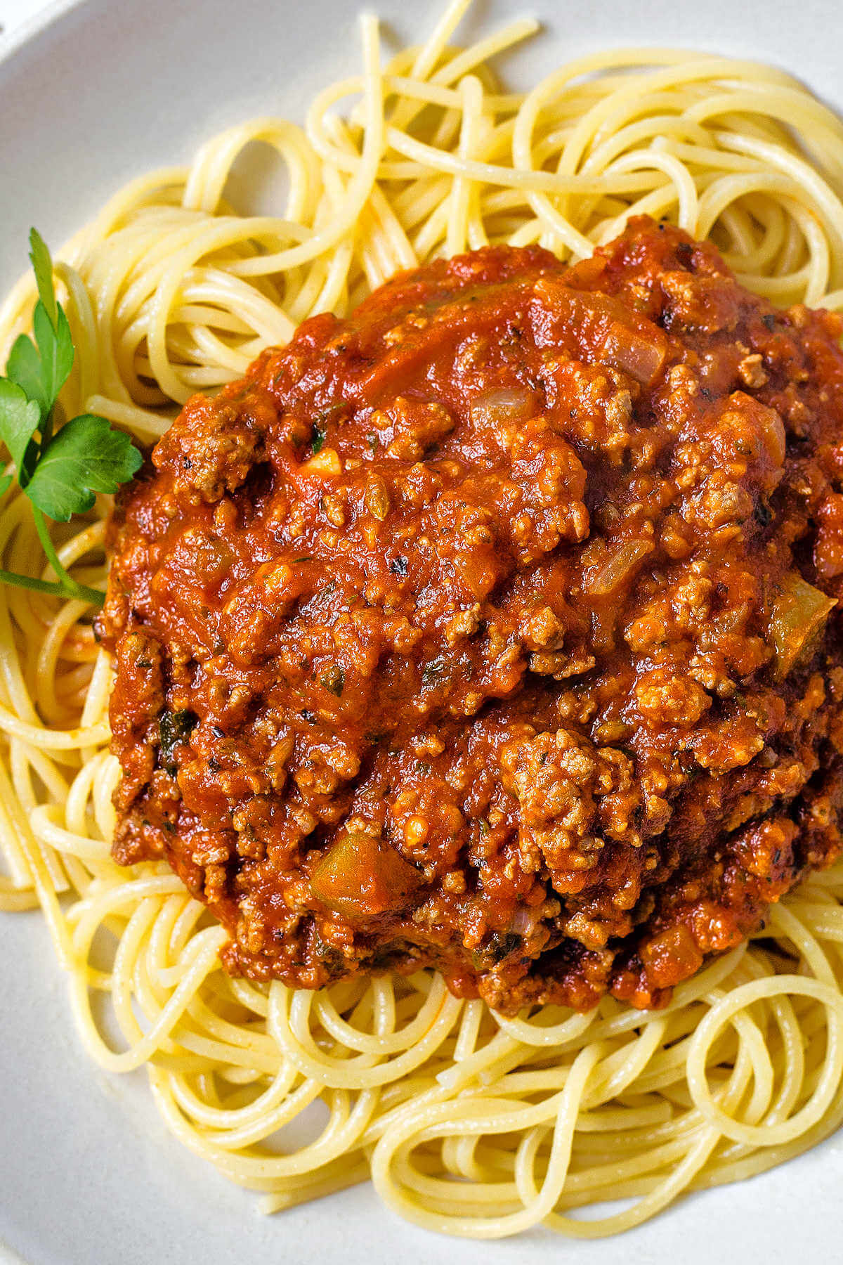 a bowl of spaghetti noodles with Italian meat sauce on top.