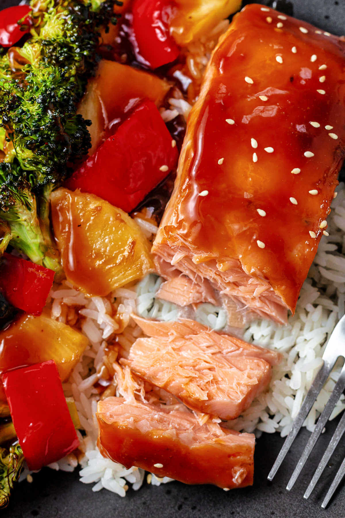 salmon flaked in a bowl of rice and roasted vegetables.