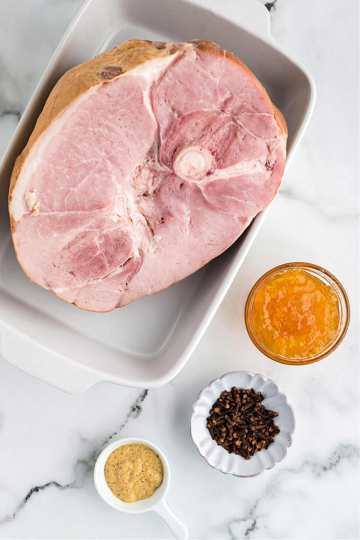 ingredients for making glazed ham on a table.