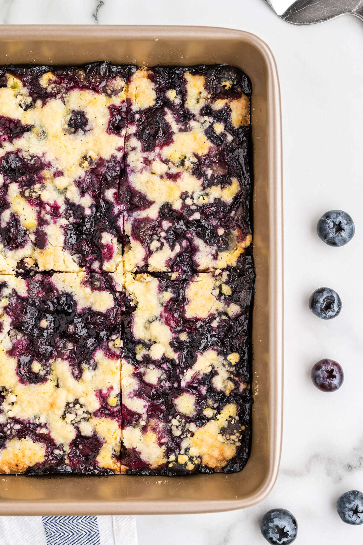 close up image of baked blueberry crumb bars in the pan.