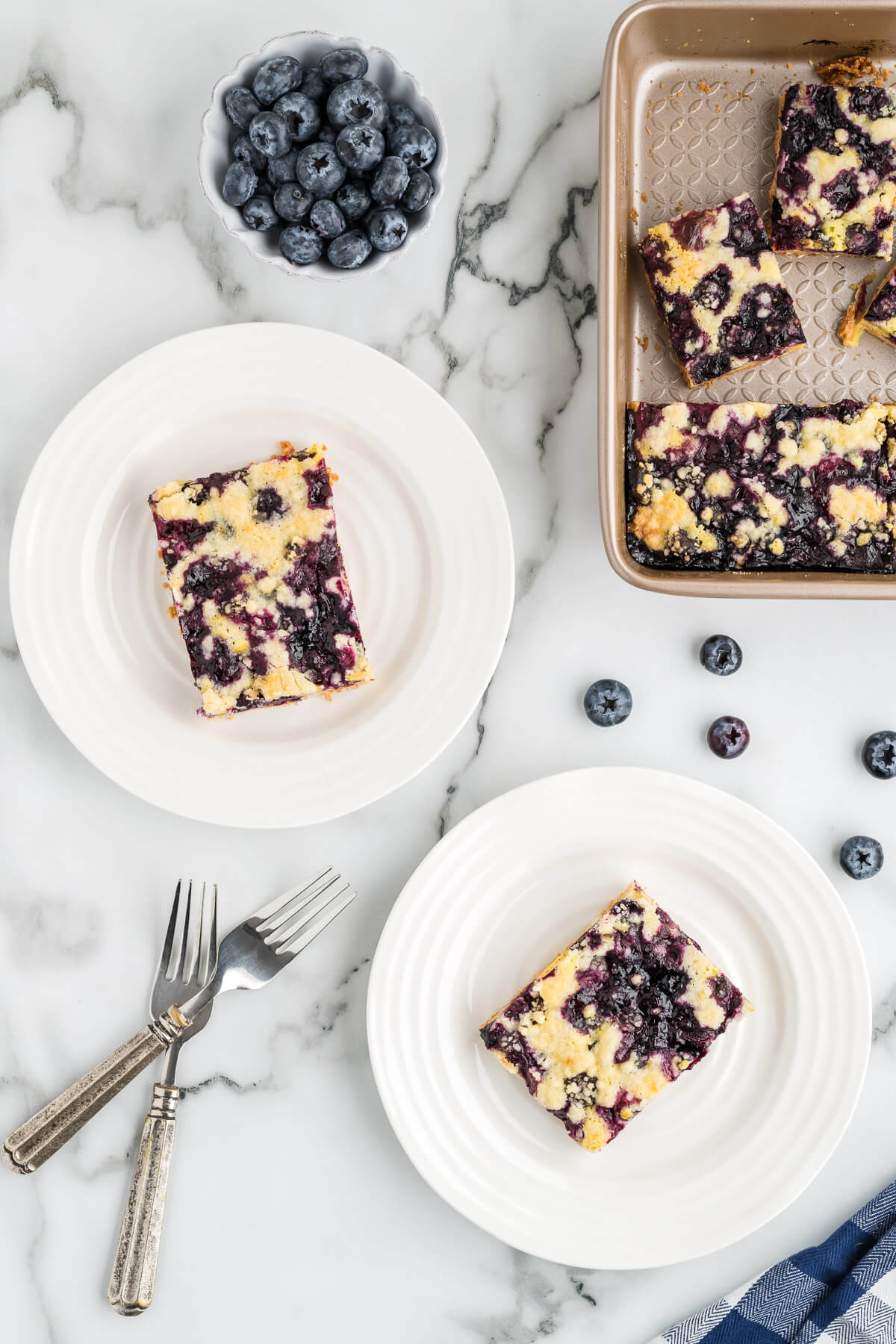 slices of blueberry crumb bars on plates on a table.