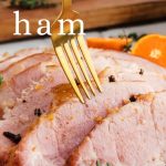 Baked Ham with Orange Mustard Glaze on a platter on a table.