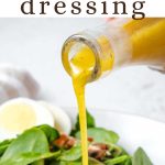 Spinach Salad Dressing being poured over salad greens.