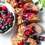 Grilled Pork Tenderloin with blueberry salsa on a white serving platter on a table.